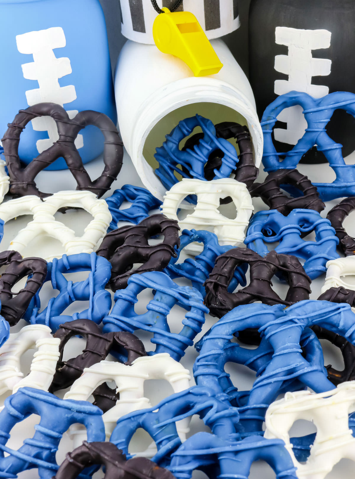 Closeup on a batch of Carolina Panthers Pretzels spilling out of a white mason jar onto a white table.