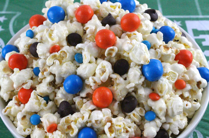 Denver Broncos Popcorn for those Denver Broncos fans in your life. Sweet, salty, crunchy and delicious and it is extremely easy to make. This delicious popcorn will be perfect at your next game day football party. a NFL playoff party or a Super Bowl party. Follow us for more fun Super Bowl Food Ideas.