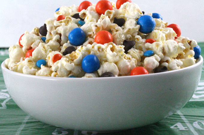 Denver Broncos Popcorn for those Denver Broncos fans in your life. Sweet, salty, crunchy and delicious and it is extremely easy to make. This delicious popcorn will be perfect at your next game day football party. a NFL playoff party or a Super Bowl party. Follow us for more fun Super Bowl Food Ideas.