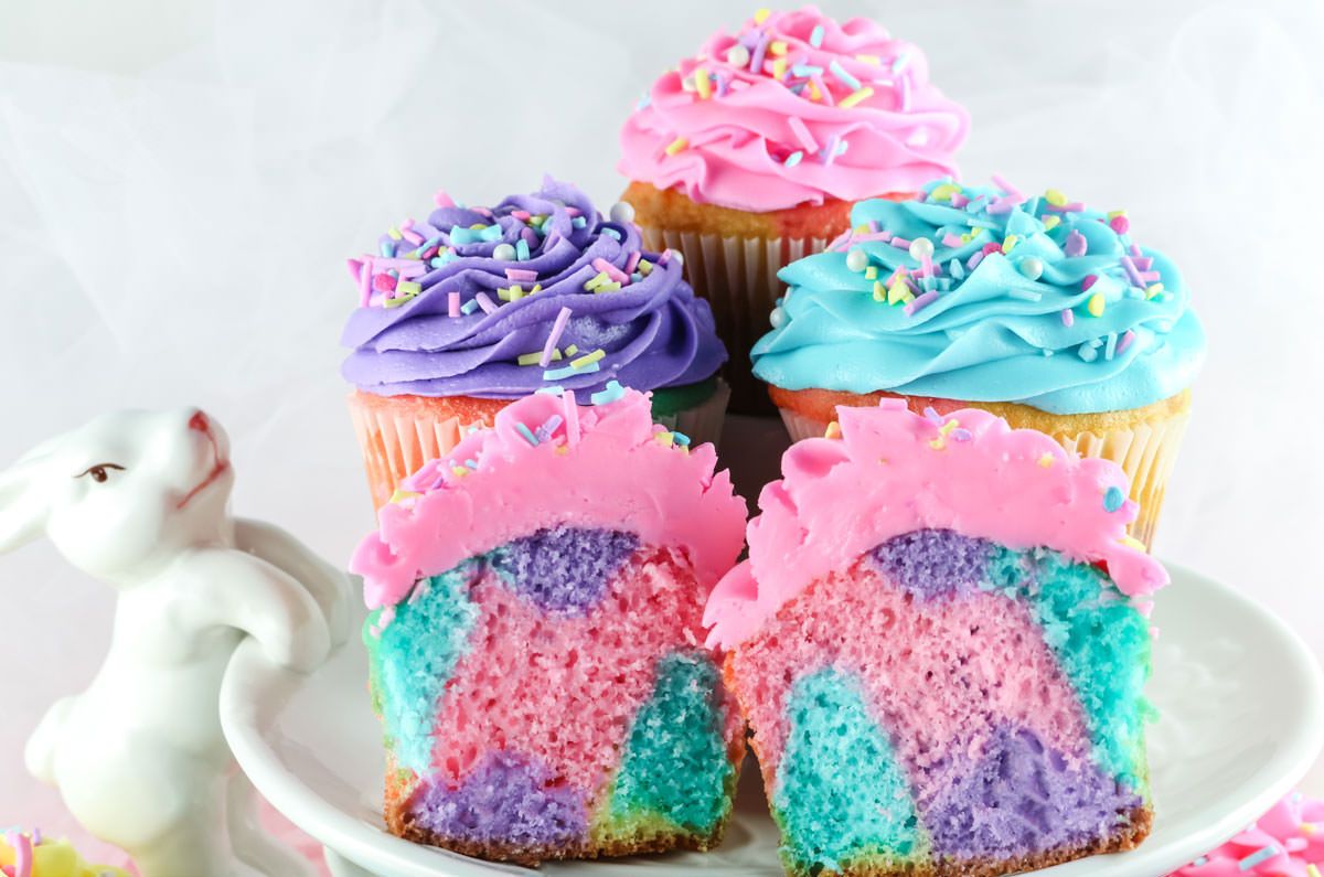 Four Celebration Marble Cupcakes sitting on a white Easter Cake Stand with a Bunny.