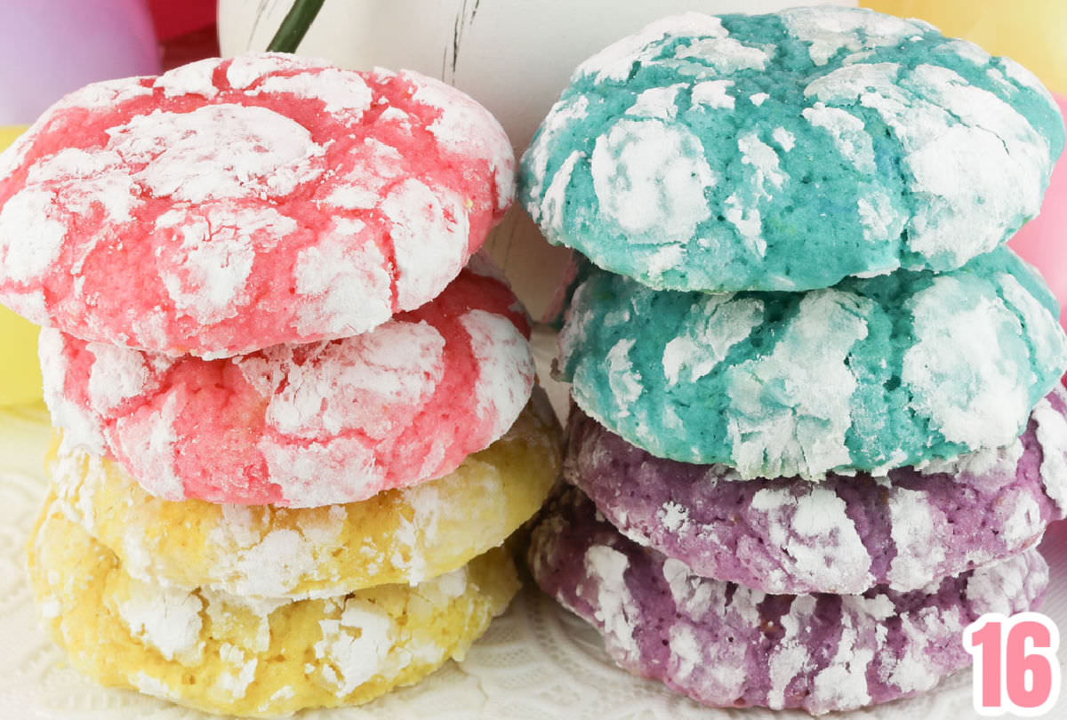 Two stacks of Lemon Crinkle Cookies sitting on a white table linen.